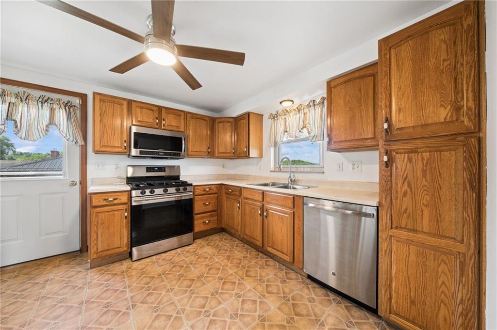711 Jane Street Pittsburgh, PA 15239 - Photo 6 of 27 Bright and functional kitchen featuring extensive upper and lower wood cabinets, ideal for all your storage needs.