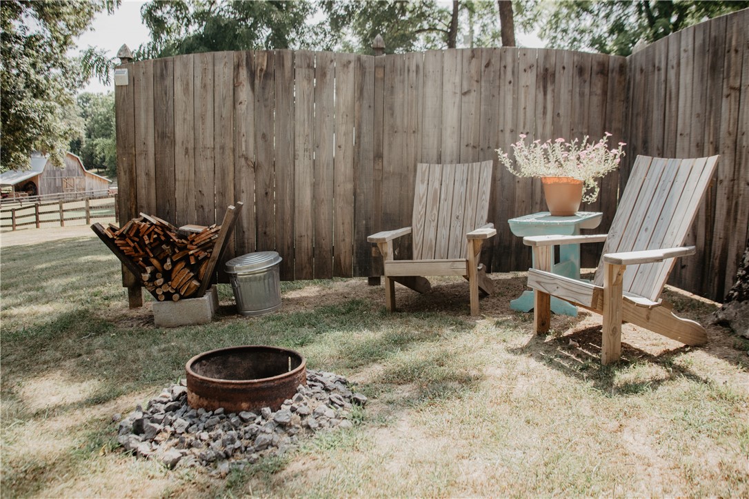 2026 Dry Creek Road St. Joe, AR 72675 - Photo 42 of 60 Wood privacy fencing enclosing a grass lawn with a built-in fire pit