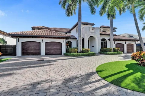 a front view of a house with a garden and trees