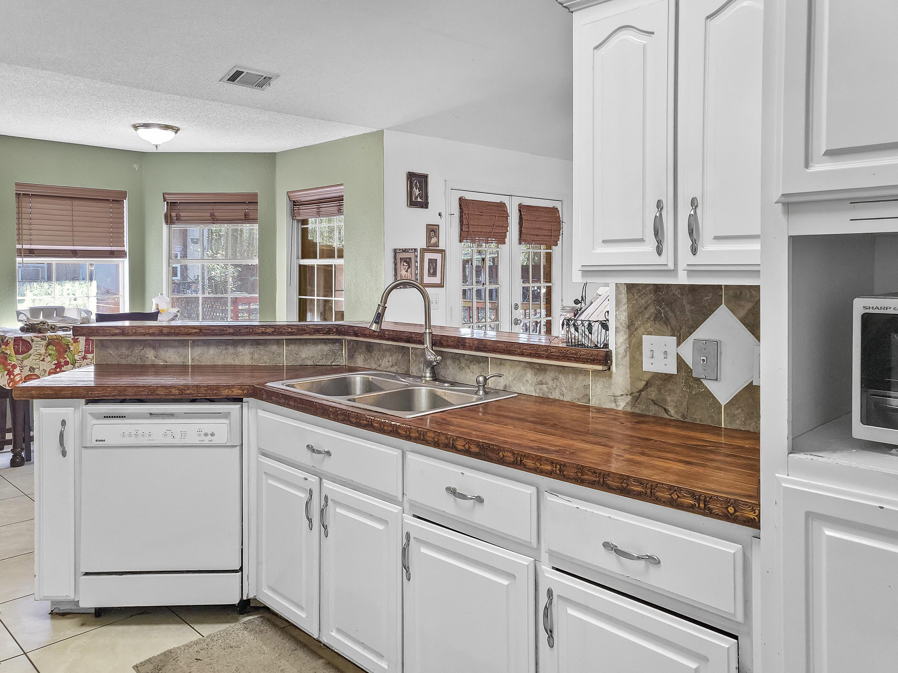 4970 East Spencer Field Road Pace, FL 32571 - Photo 3 of 15 a kitchen with white cabinets and sink
