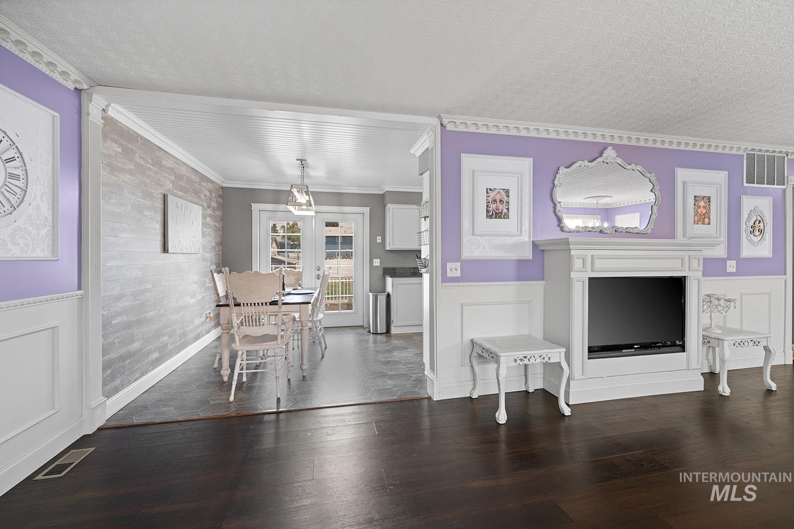 2007 Ripon Avenue Lewiston, ID 83501 - Photo 5 of 30 Open-concept living space featuring dark wood-finish flooring, white wainscoting, and decorative crown molding