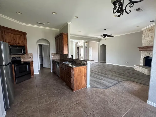 a large kitchen with stainless steel appliances granite countertop a stove and a refrigerator