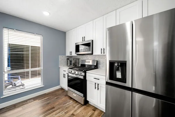 a kitchen with stainless steel appliances a refrigerator sink and microwave