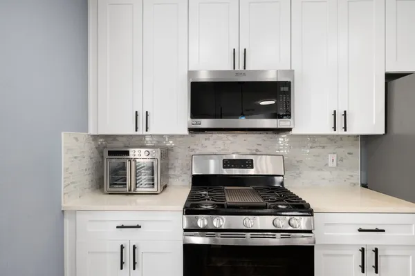 a stove top oven sitting inside of a kitchen