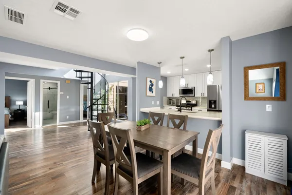 a view of a dining room and livingroom with furniture wooden floor and a rug