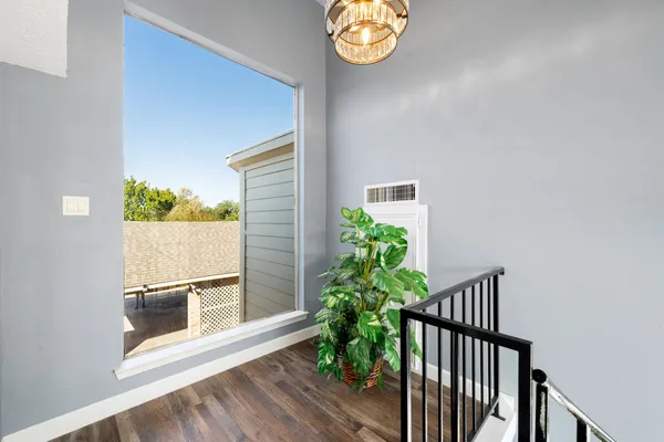a view of a hallway to a house with wooden floor