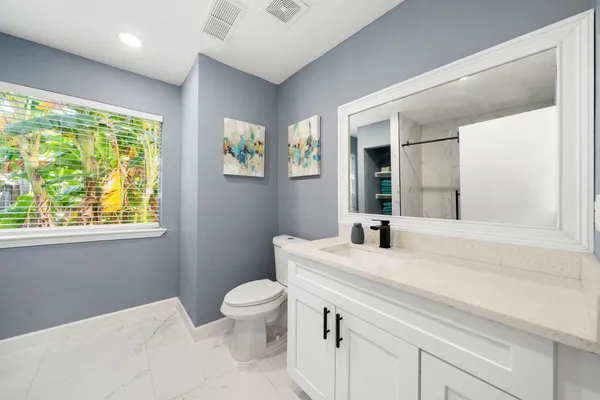 a bathroom with a sink a toilet and a window