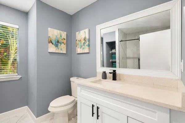 a bathroom with a sink a toilet and a window