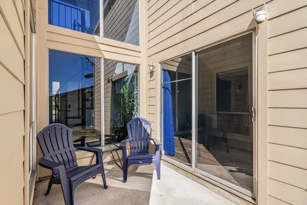 a view of a door with a chairs and table in a patio
