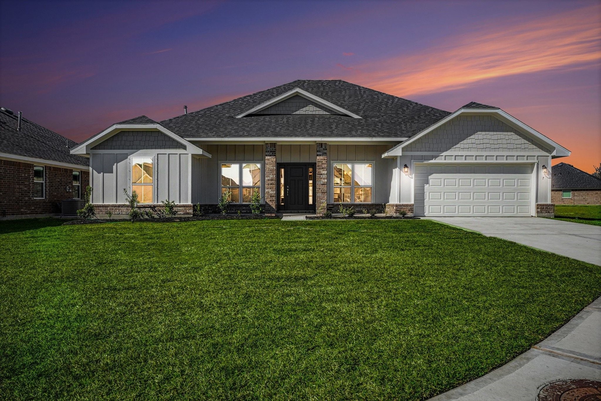 a front view of a house with a yard and trees