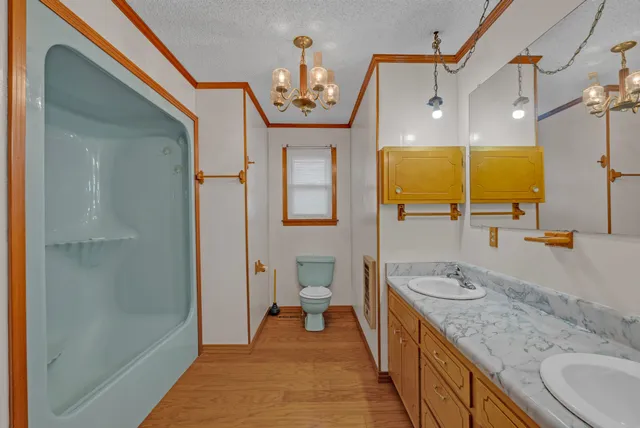 a spacious bathroom with a granite countertop sink a mirror and shower
