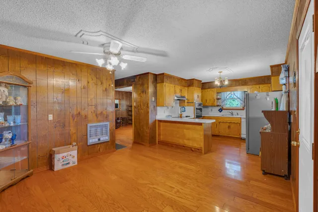 a large kitchen with stainless steel appliances a large counter top a stove and a refrigerator