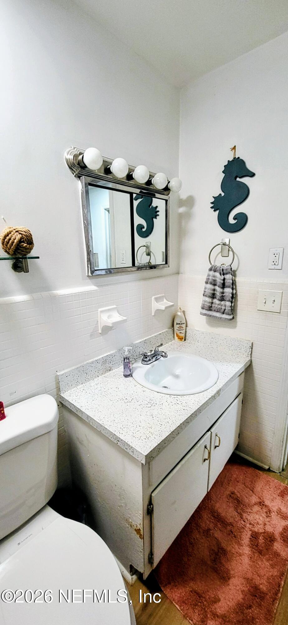 1647 El Camino Road, Unit 5 Jacksonville, FL 32216 - Photo 13 of 36 a bathroom with a granite countertop toilet sink and mirror