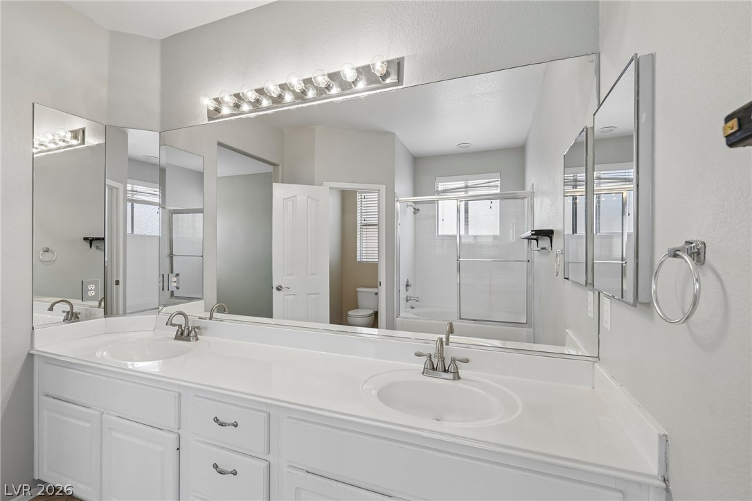 1727 Millstream Way Henderson, NV 89074 - Photo 28 of 46 Dual vanities and a spacious shower offer everyday convenience in this polished bathroom.