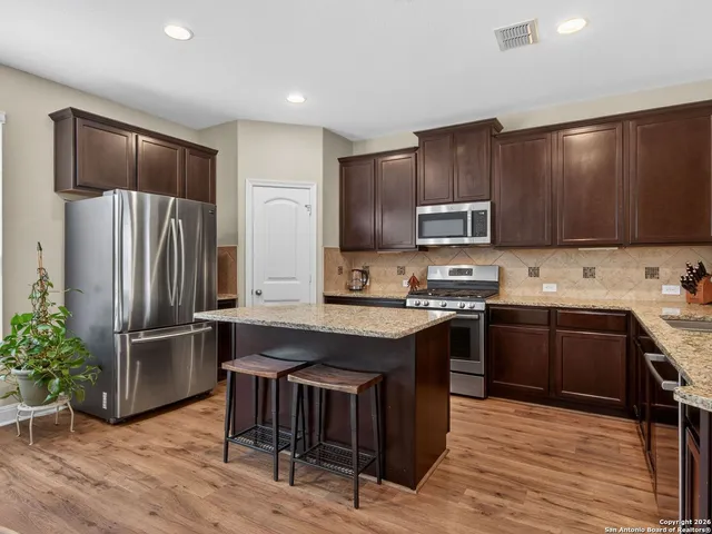 a kitchen with granite countertop stainless steel appliances and wooden cabinets