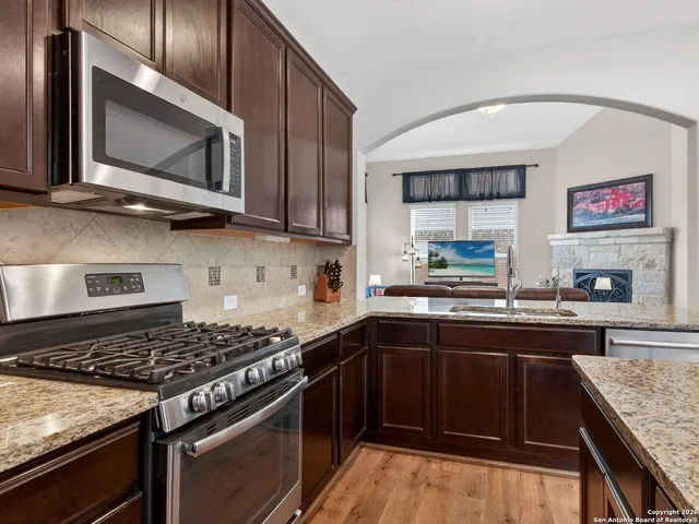 a kitchen with stainless steel appliances granite countertop a stove microwave and sink
