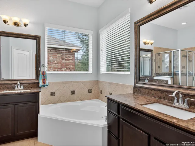 a bathroom with a granite countertop sink and a large mirror