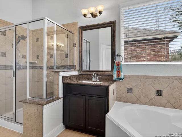 a bathroom with a tub sink and mirror