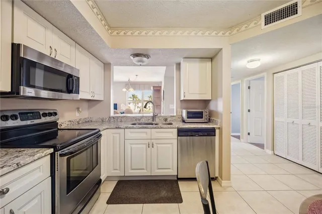 a kitchen with granite countertop a stove sink and microwave