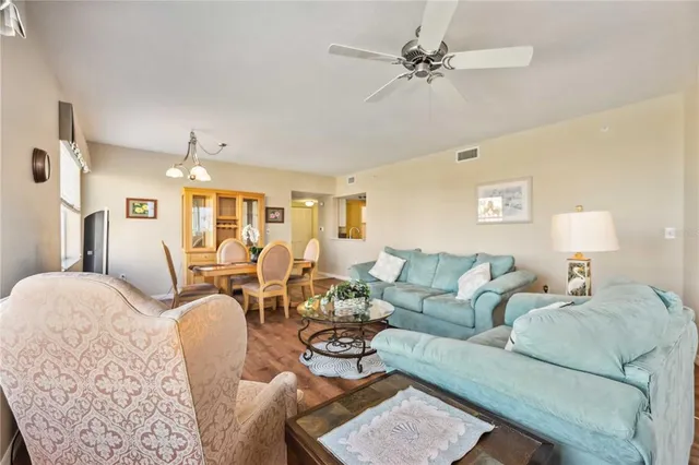 a living room with furniture a chandelier and a dining table