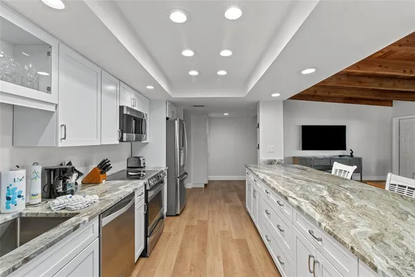 a kitchen with stainless steel appliances granite countertop a sink stove and refrigerator