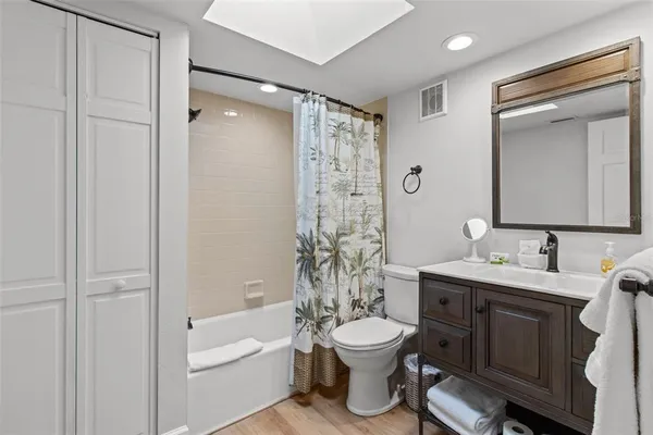 a bathroom with a granite countertop toilet sink and mirror