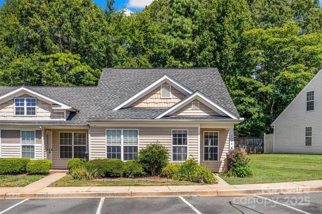 a front view of a house with a yard and potted plants