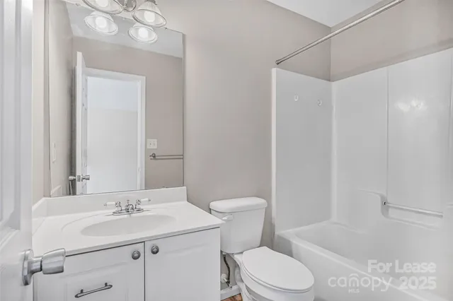 a bathroom with a sink toilet vanity and tub