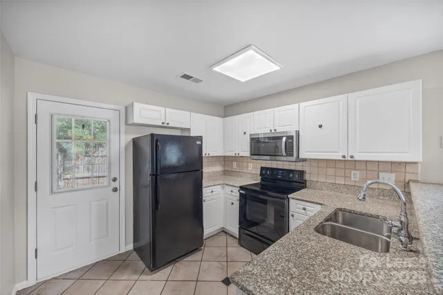 a kitchen with a refrigerator sink and cabinets