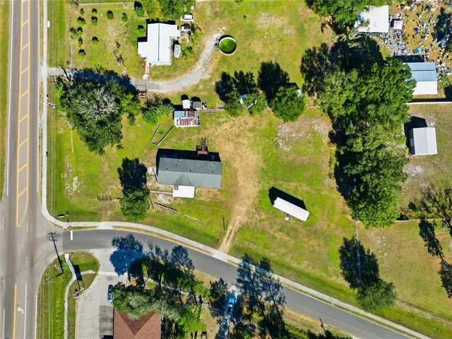 an aerial view of a residential houses with yard