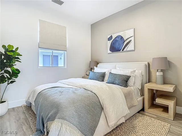 a bedroom with bed and a painting on the wall