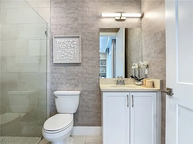 a bathroom with a granite countertop toilet sink and mirror