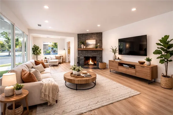 a living room with furniture a flat screen tv and a fireplace