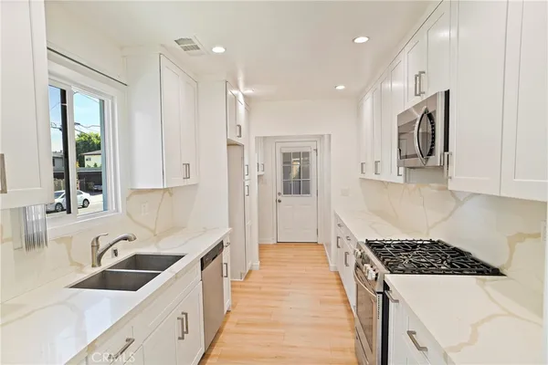 a kitchen with stainless steel appliances granite countertop a sink stove and refrigerator