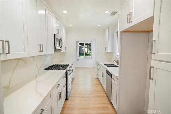 a kitchen with granite countertop a sink and a stove top oven