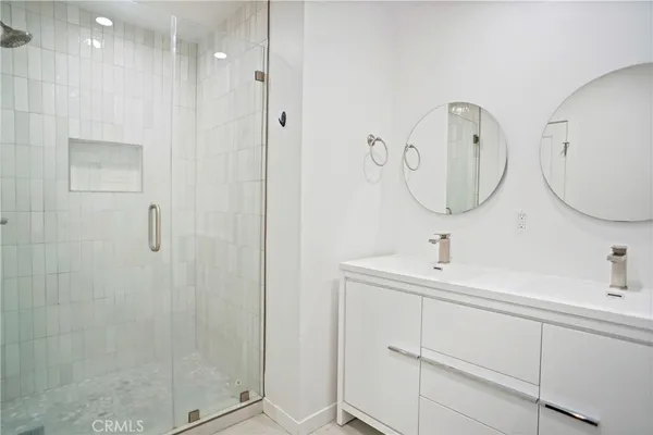 a bathroom with a double vanity sink mirror and shower