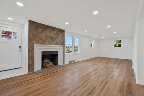 a view of empty room with wooden floor and fireplace