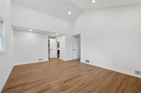 a view of an empty room with wooden floor