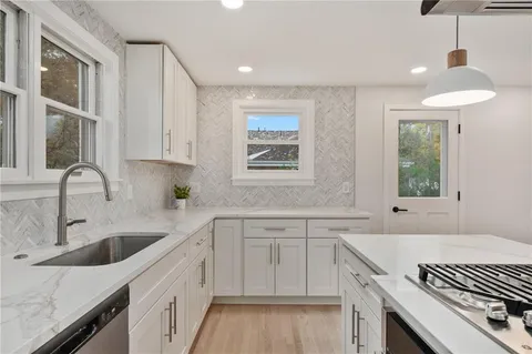 a kitchen with a sink stove top oven and cabinets