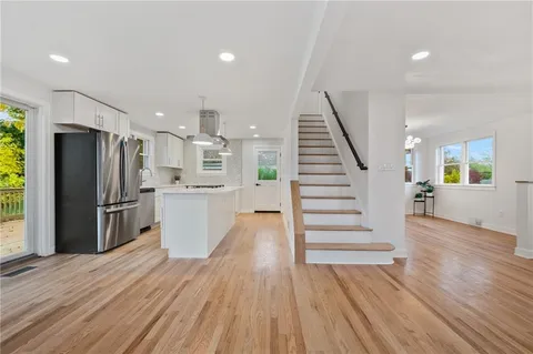 an open kitchen with a refrigerator and a stove top oven
