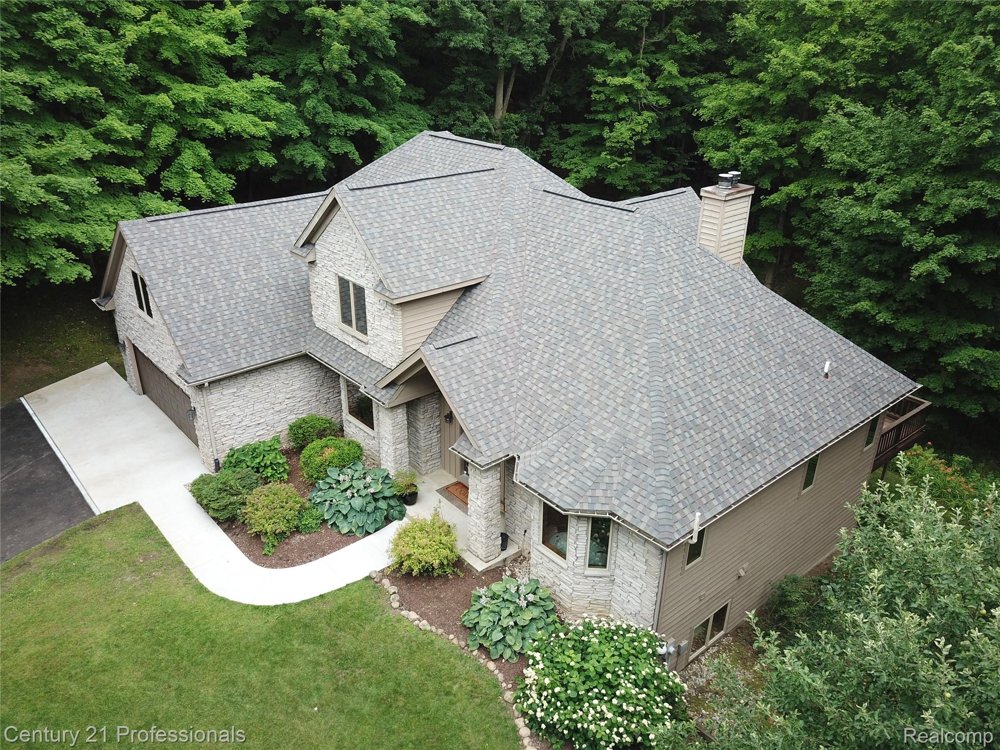 9867 Rainbow Ridge Drive Schoolcraft, MI 49087 - Photo 5 of 82 Stone veneer exterior with a concrete driveway and an attached garage