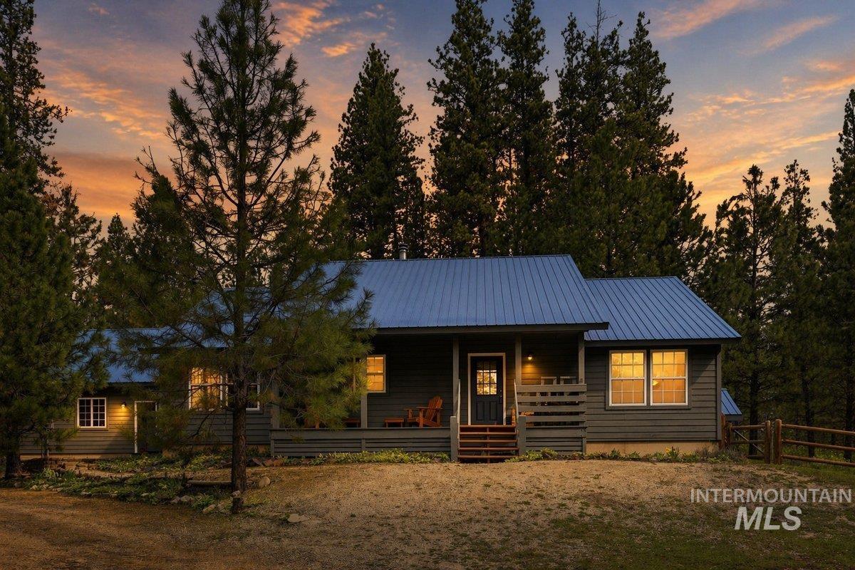 Ranch-style residence featuring dark gray horizontal siding and a blue metal roof