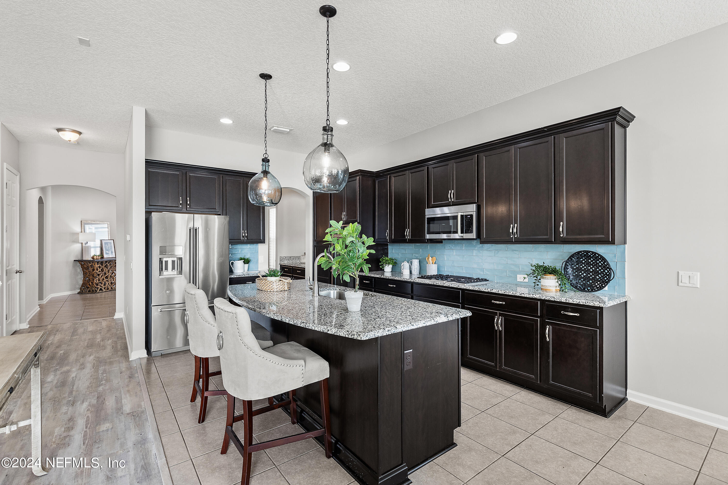 143 Willow Lake Drive St. Augustine, FL 32092 - Photo 5 of 45 a kitchen with stainless steel appliances granite countertop a stove a sink a microwave a refrigerator and chairs