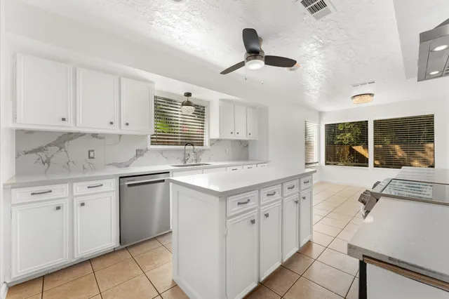a kitchen with granite countertop cabinets a sink and appliances