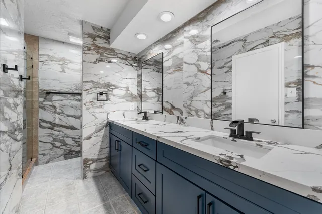 a bathroom with a double vanity sink mirror and shower