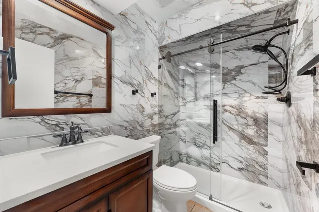 a bathroom with a sink toilet and shower