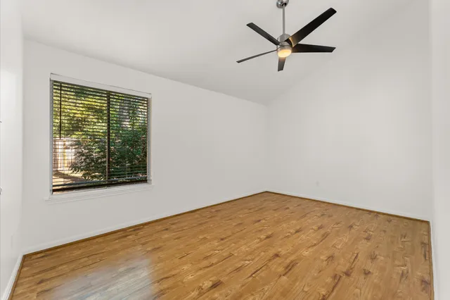 an empty room with a window and a ceiling fan