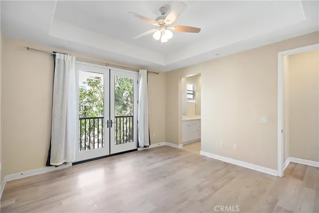 an empty room with windows and ceiling fan