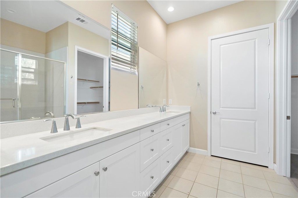 199 Follyhatch Irvine, CA 92618 - Photo 31 of 32 a bathroom with a double vanity sink and mirror