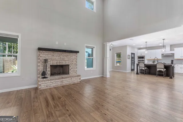 a kitchen with stainless steel appliances granite countertop a dining table chairs refrigerator and cabinets